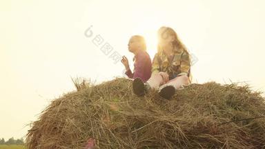 少年女孩坐着有堆栈晚上日落背景女孩青少年放松干草堆收获场女孩休息干草堆村金日落